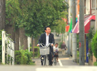 自転車で営業活動を行う支店長のイメージ写真です
